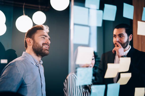istock Colleagues looking at glass with stickers 1459665179