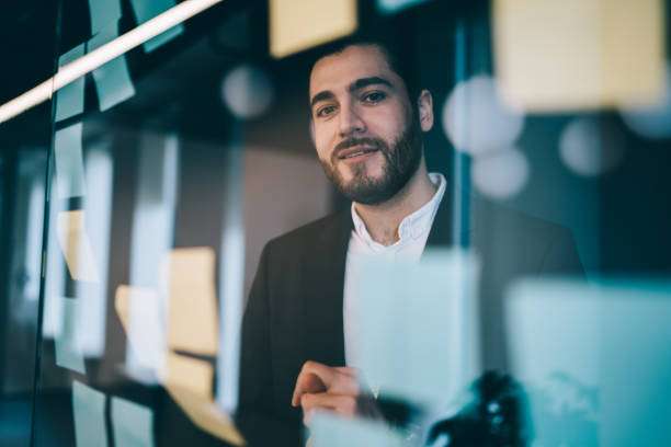 istock Cheerful man looking through glass board in office 1459665427