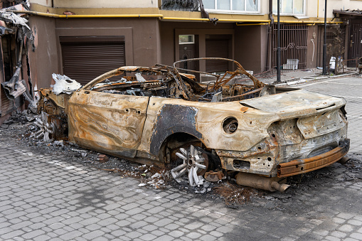 arson for revenge. burnt car parked on the street, close-up
