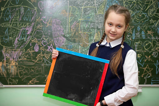 Schoolgirl of middle school age with an empty slate board.