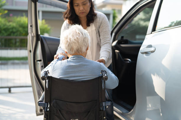 Asian senior or elderly old lady woman patient sitting on wheelchair prepare get to her car, healthy strong medical concept. Asian senior or elderly old lady woman patient sitting on wheelchair prepare get to her car, healthy strong medical concept. senior adult car nurse physical impairment stock pictures, royalty-free photos & images