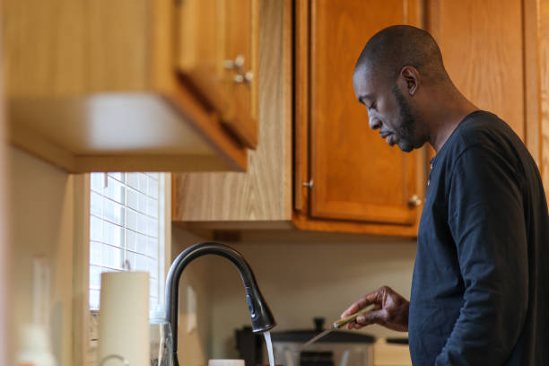 istock A black man washing dishes at a kitchen sink 1459673899