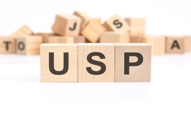 istock text USP - Unique Selling Proposition - is written on three wooden cubes standing on a white table. in the background - a mountain of wooden cubes with letters. 1459678274