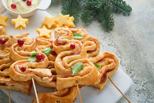 istock Christmas or New Year appetizer. Christmas tree shape puff pastry buns with cheese and ham. Group of Christmas tree shapes on marble stand. Festive idea for Christmas or New Year dinner. Top view. 1459679074