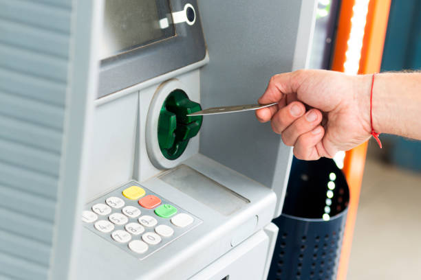 Human hand inserting a credit card into an ATM