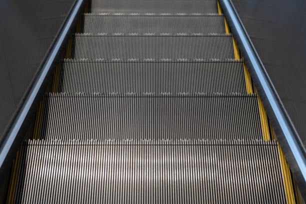 escaliers mécaniques dans le centre commercial - railroad station escalator staircase steps photos et images de collection