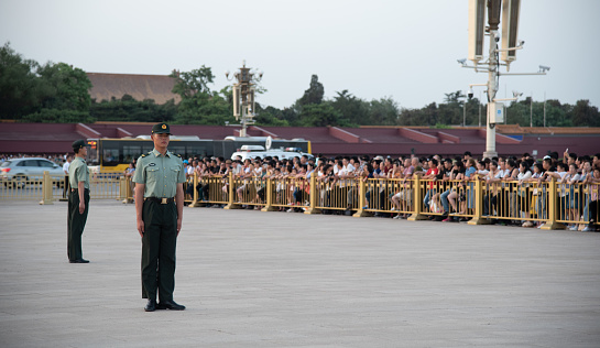 Beijing, China , June 2018: Security guard on the entrance of the famous Forbidden palace city with the portrait chairman Mao Zedong in Beijing, China.