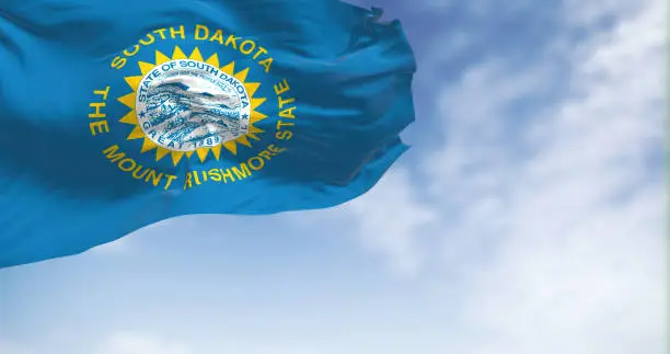 The South Dakota flag waving in the wind on a sunny day. A realistic 3D illustration. Fabric fluttering and flapping. A federated American state located in the high plains of the Midwest