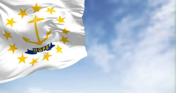 Rhode Island state flag waving on a clear day. Gold anchor in the center surrounded by thirteen gold stars. Rippling fabric. Textured background. Selective focus. Realistic 3d illustration