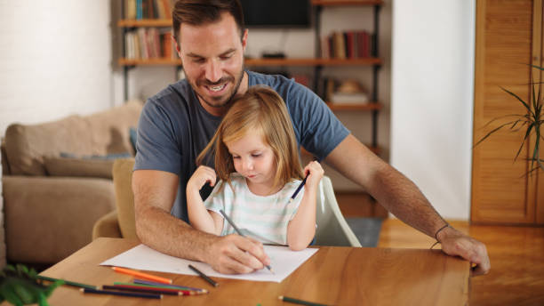 istock Father and daughter having good time drawing at home together 1459687951