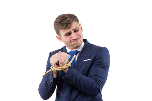 Portrait of a handsome man in a suit with hands tied is trying to free himself. concept of financial dependence and slavery. . High quality photo