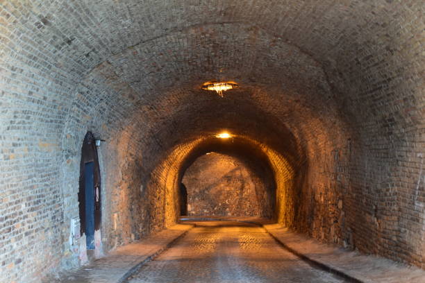 istock Old tunnel with a yellow lightning and brick walls 1459693276