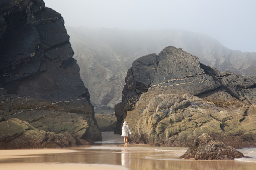 Figure with Sea, Cliffs and Rocks With Mist at Odeceixe Beach; Algarve; Portugal