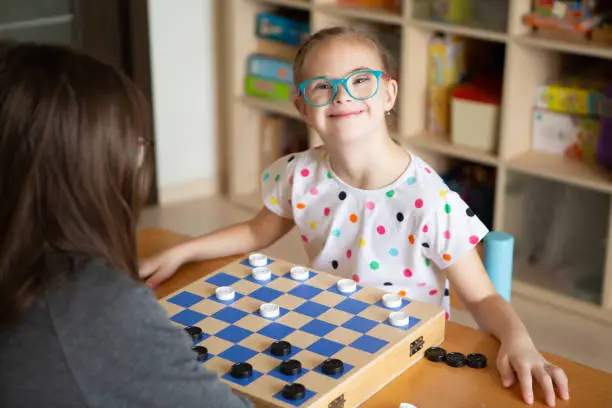 Photo of Girl with Down Syndrome playing checkers