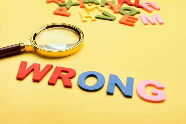 istock Word wrong and magnifying glass on the yellow background. 1459702625