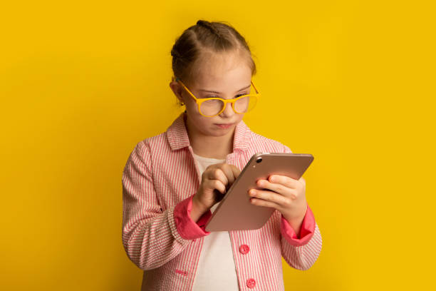 istock Girl with Down Syndrome plays on a tablet 1459702979