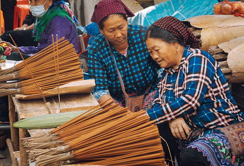 Bac Ha, Vietnam - November 13 : Women sell incense sticks at Bac Ha Market, Vietnam. The market, held every Sunday, is a very colorful market where hilltribe people come to trade for goods.