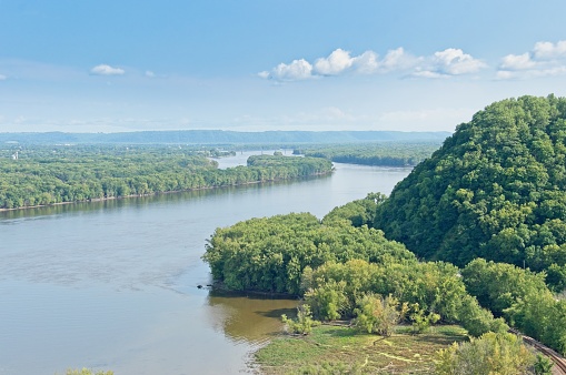 Above the Mississippi river in Iowa with railroad tracks along the flood plain. High angle view from Effigy Mounds national monument across the Mississippi towards Wisconsin. This upper Mississippi section or the river is a major transportation thoroughfare.