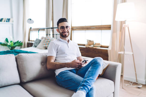 istock Handsome man sitting on sofa in modern room 1459713432