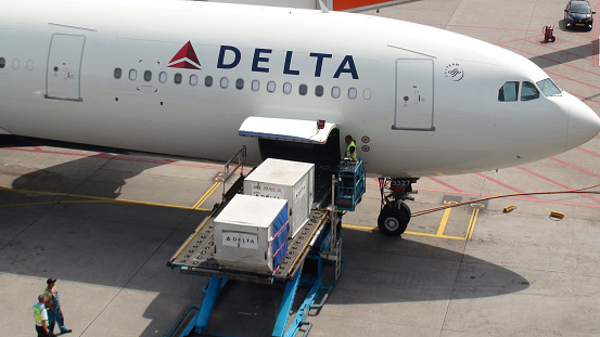 Airport Ground Crew Loading Goods Into Delta Airlines Passengers Airplane At Schiphol International Airport Amsterdam The Netherlands Europe