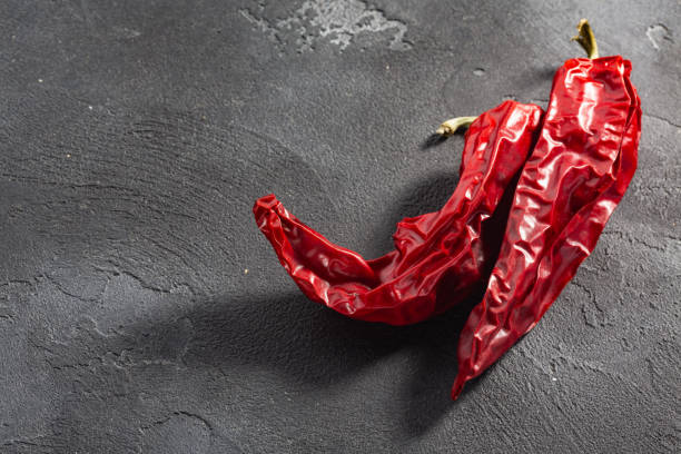 istock Dried Numex chile pepper pods over dark background, top view, copy space 1459716330