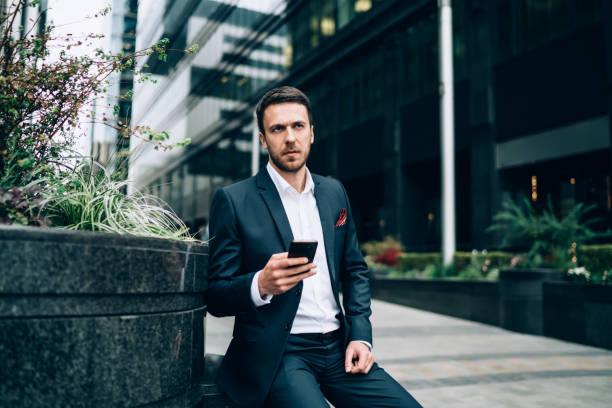 istock Pensive boss surfing phone resting in business district 1459718410