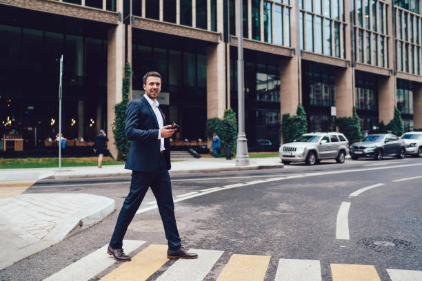 istock Friendly entrepreneur with smartphone walking on crosswalk 1459718473