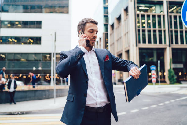 istock Businessman speaking on smartphone and checking time 1459718506