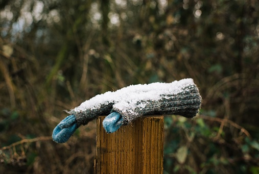 frozen lost glove with snow on it resting on a post in Winchester, England, United Kingdom