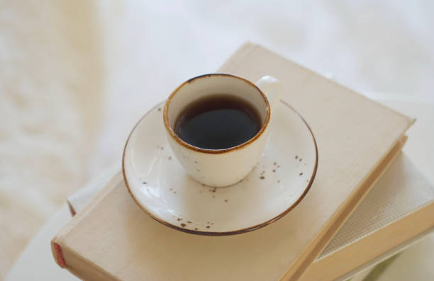 istock A mug of black coffee stands on a stack of books on the table 1459720766