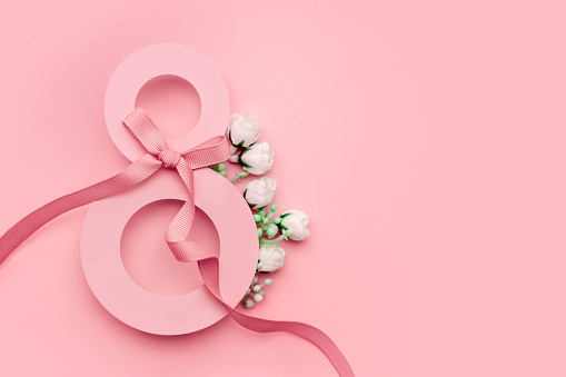 Postal 8 de marzo. Papel número ocho decorado con flores de primavera sobre fondo rosa photo
