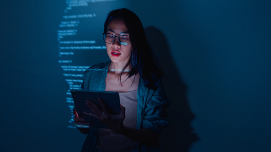 Young Asian woman software developers mentor leader manager talking to executive team analyzing source code in office at night. Programmer development concept.