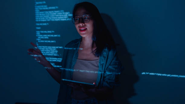istock Young Asian woman software developers mentor leader manager talking to executive team analyzing source code in office at night. 1459731752