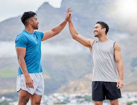 High five, man and friends for outdoor fitness in summer, sport and happy by mountain. Teamwork, support and hands together in success, wellness or workout for health, goal or training in Cape Town