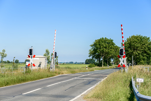 Level crossing with barriers raised for traffic to pass over in the countryside of Germany on a clear summer day. Wremen, Germany.
