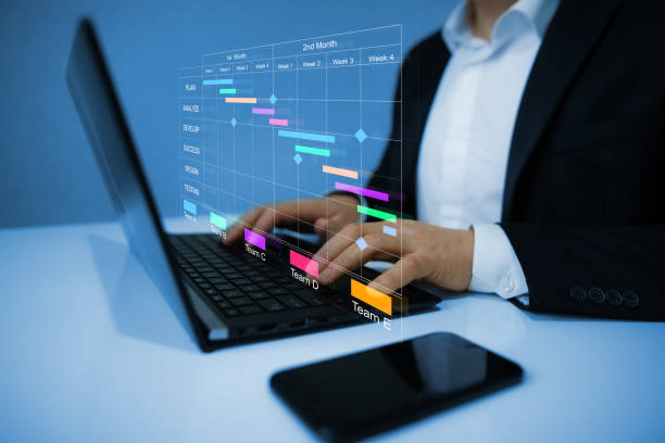 istock Project manager working on laptop and updating tasks and milestones progress planning with Gantt chart scheduling interface for company on virtual screen. Business Data Management System. 1459741932
