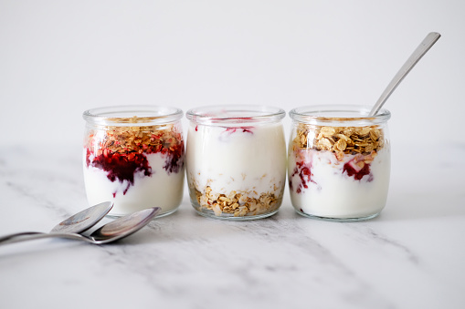 Granola (oatmeal muesli) with yogurt in glass served. Weight loss diet concept Detox menu. Tasty vegetarian breakfast, snack or dessert. Healthy eating concept. Morning table background