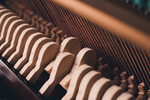 Old vintage piano hammers with strings close up. Selective focus.