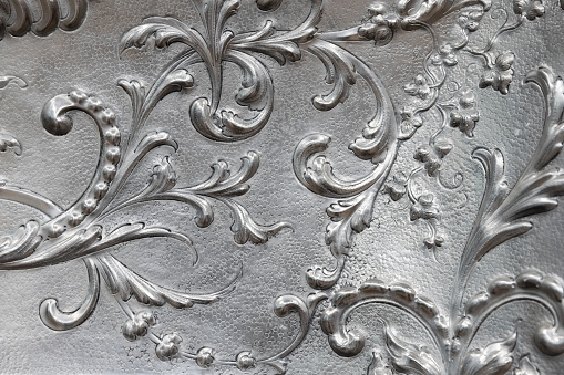 Shiny silver coinage, classic floral patterns, close up photo