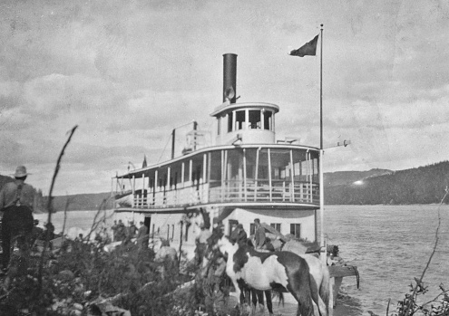 Loading horses aboard a paddle steamer boat on the Peace River in Alberta, Canada. Vintage photograph ca. 1914.