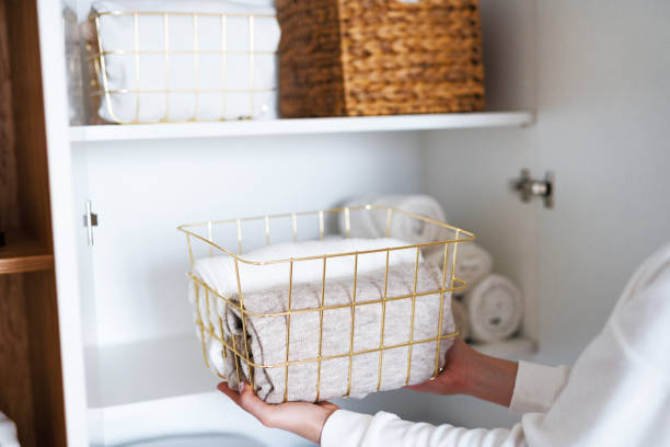 istock Woman organizing clothes on shelves in white opened wardrobe, folding laundry in baskets. Space organization and storage system 1459754874