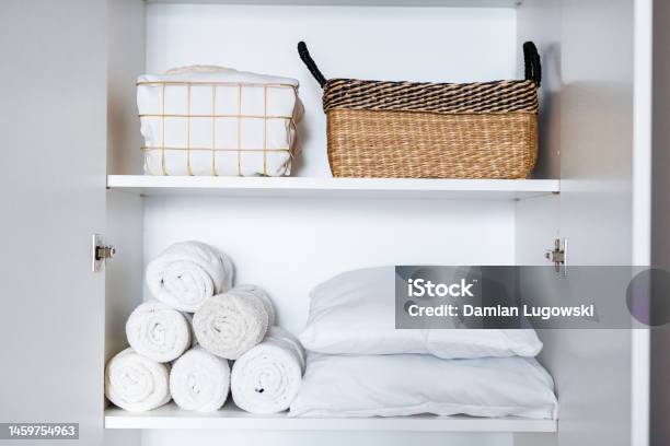 White Laundry Pillows Towels Organized And Folded In Baskets On Shelves In White Wardrobe Space Organization Stock Photo - Download Image Now