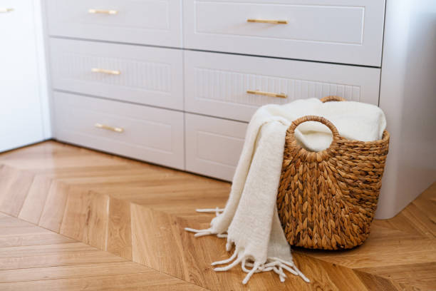 Wardrobe drawers and woven wicker basket for laundry with white blanket, close up. stock photo