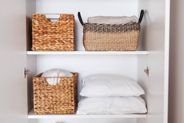 istock Laundry, pillows, towels organized and folded in wicker baskets on shelves in white wardrobe 1459756005