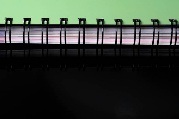 Cover edge of a spiral notepad for notes on a black mirrored background with space for information and text