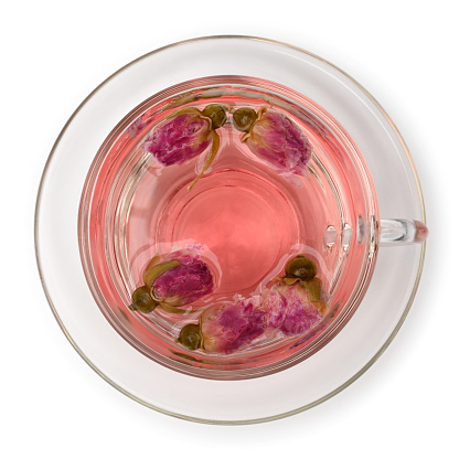 Rose tea in glass cup top view on white background