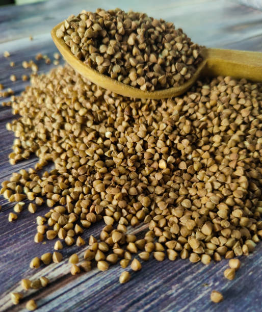istock Raw buckwheat on a wooden table with a slide, a wooden spoon filled with buckwheat. 1459765708