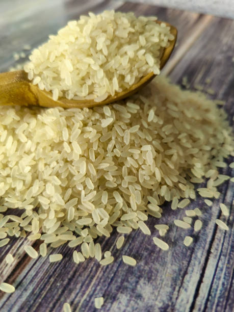 istock Raw rice on a wooden table in a pile 1459765801