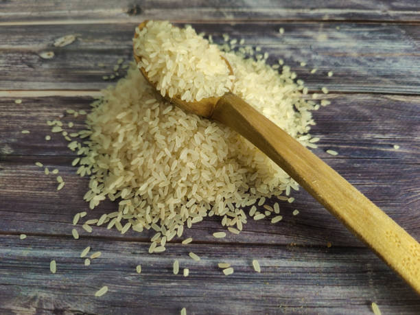 istock Raw rice on a wooden table in a pile 1459765872