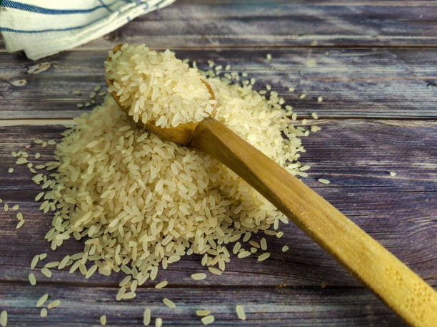 istock Raw rice on a wooden table in a pile 1459766049